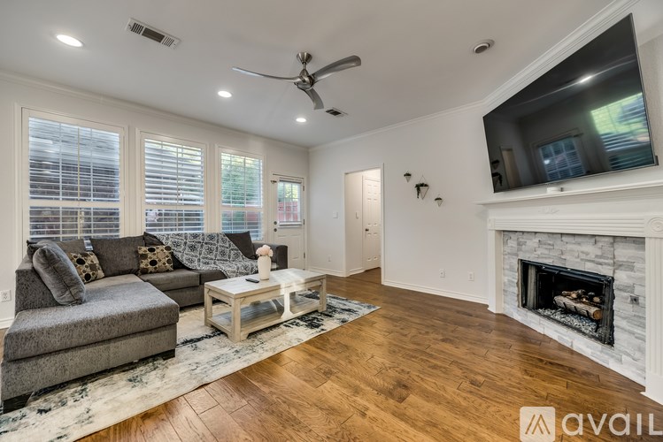 A living room with a grey couch, a coffee table, and a fireplace.