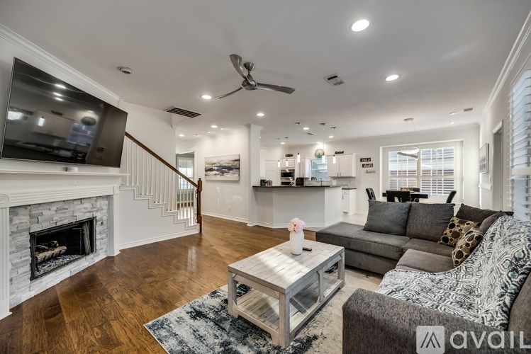 A modern living room with a fireplace and a grey sofa.