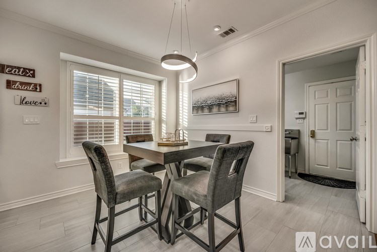 A dining room with a table and chairs.