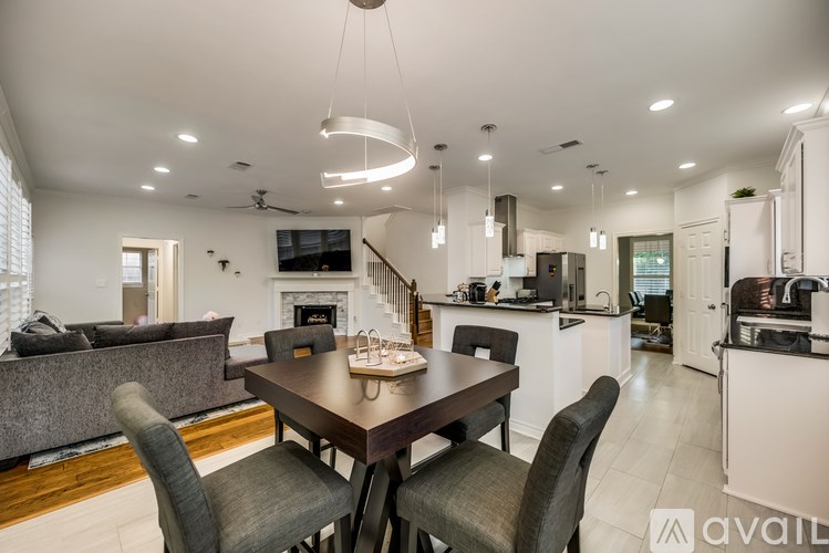 A modern dining room with a dark wood table and grey chairs.