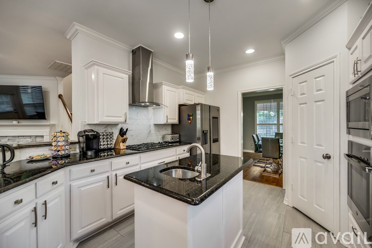 A kitchen with white cabinets and a black countertop.