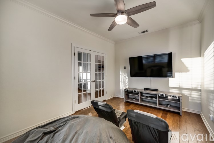 A living room with a grey sofa and a television mounted on the wall.