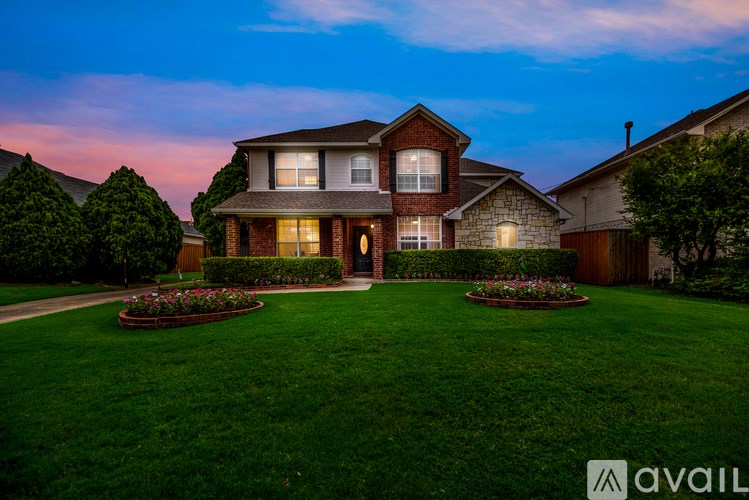 A house with a well-manicured lawn and a garden in front.
