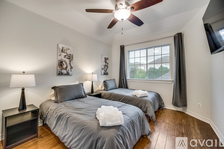 Two twin beds in a room with a ceiling fan.