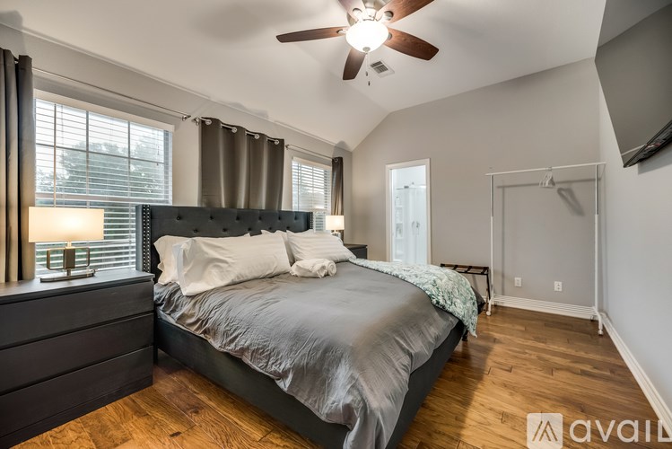 A bedroom with a large bed and a ceiling fan.