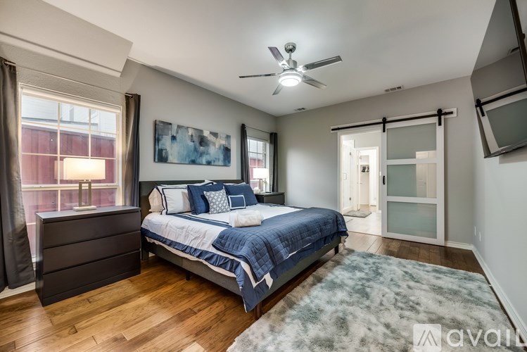 A bedroom with a bed, dresser, and ceiling fan.