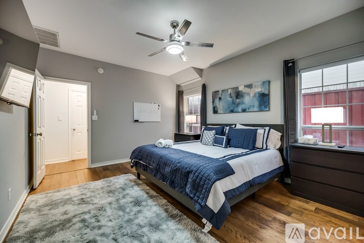 A bedroom with a bed, a ceiling fan, and a rug.