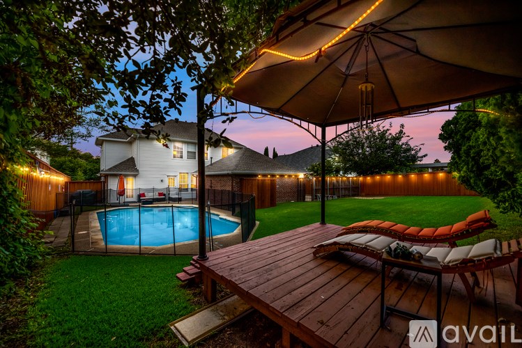 A backyard with a pool and deck area.