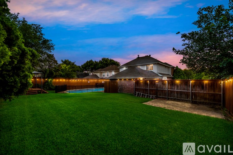 A backyard with a pool and a house.