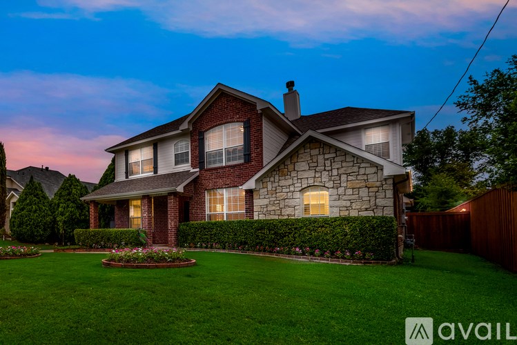 A house with a well-maintained lawn and a stone wall.