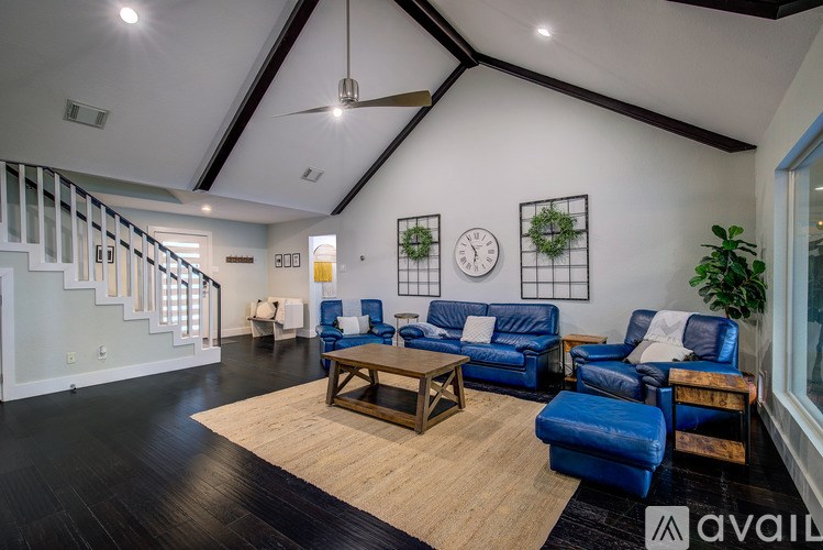 A living room with blue couches and a wooden coffee table.