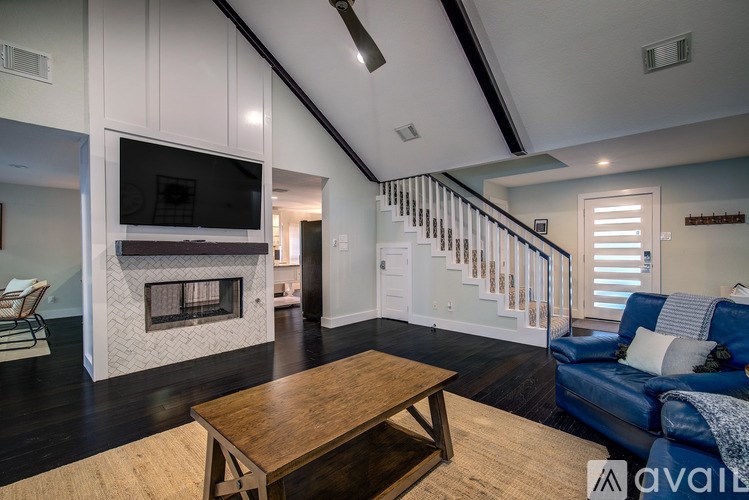 A living room with a fireplace and a television on the wall.