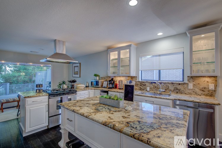 A kitchen with granite countertops and stainless steel appliances.