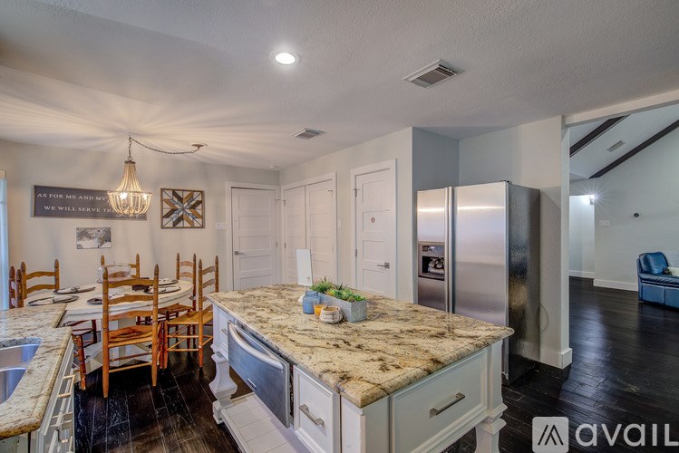 A kitchen with a granite countertop and a chandelier.