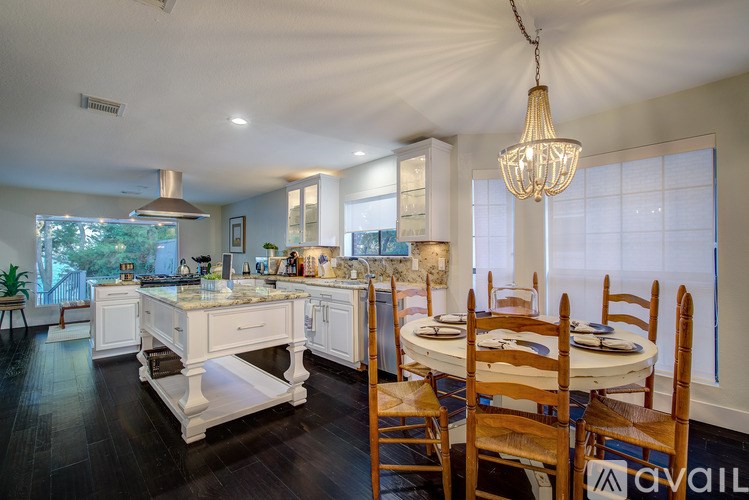 A well-lit kitchen with a dining table set for four.
