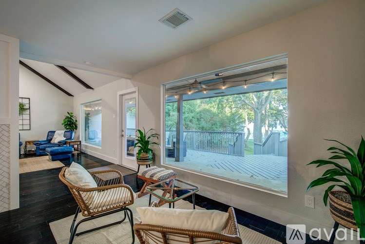 A living room with a sofa, chair, and potted plants.