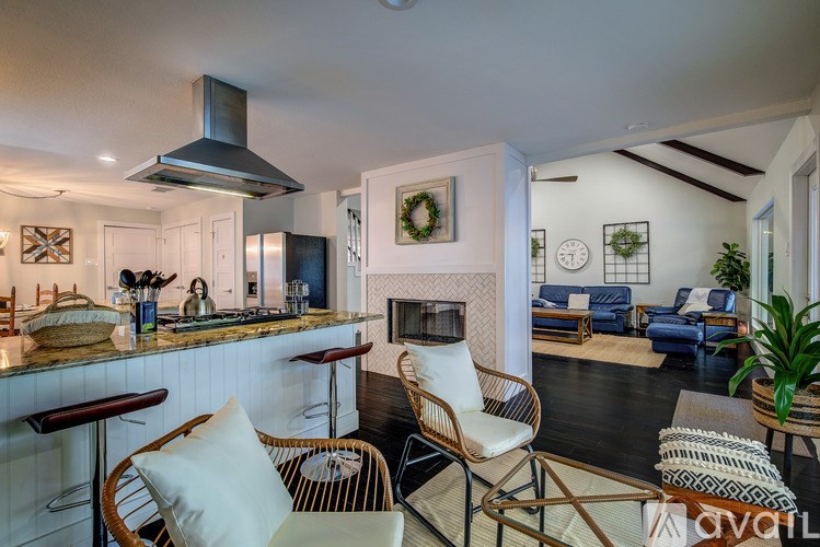 A modern kitchen with a bar area and a living room area.