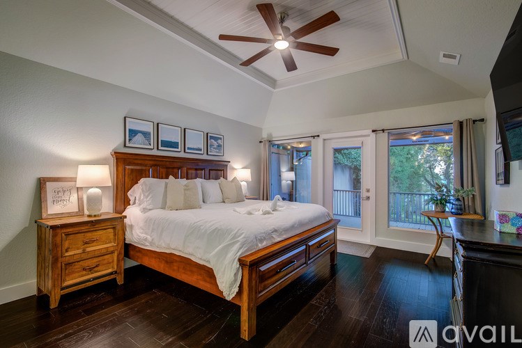 A bedroom with a bed, dresser, and a ceiling fan.