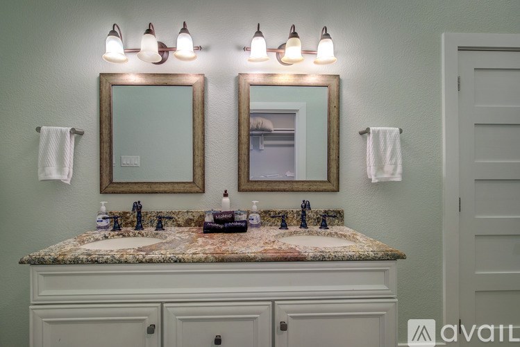 A bathroom with a marble countertop and two framed mirrors.