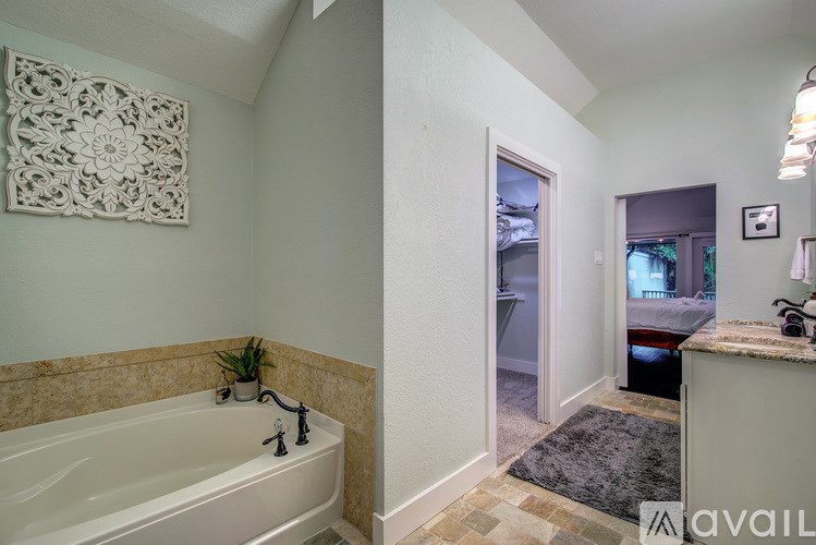 A bathroom with a tub and a window.