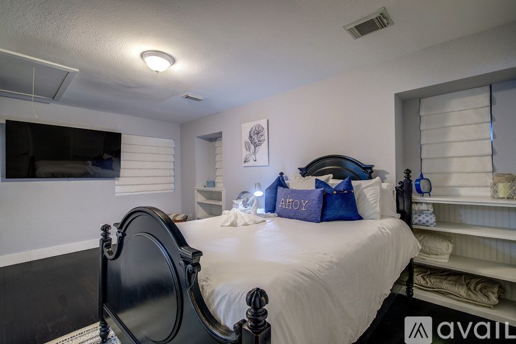 A bedroom with a black bed and white walls.
