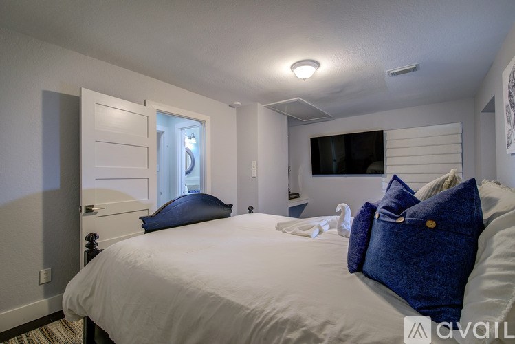 A bedroom with a large bed and a flat screen TV mounted on the wall.