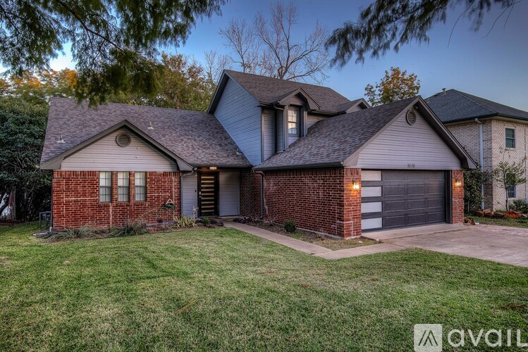 A house with a garage and a driveway is available for sale.