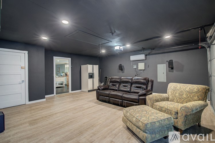 A living room with a brown leather couch and a patterned armchair.
