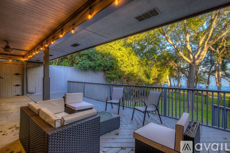 A patio with a couch, chairs, and a hot tub.