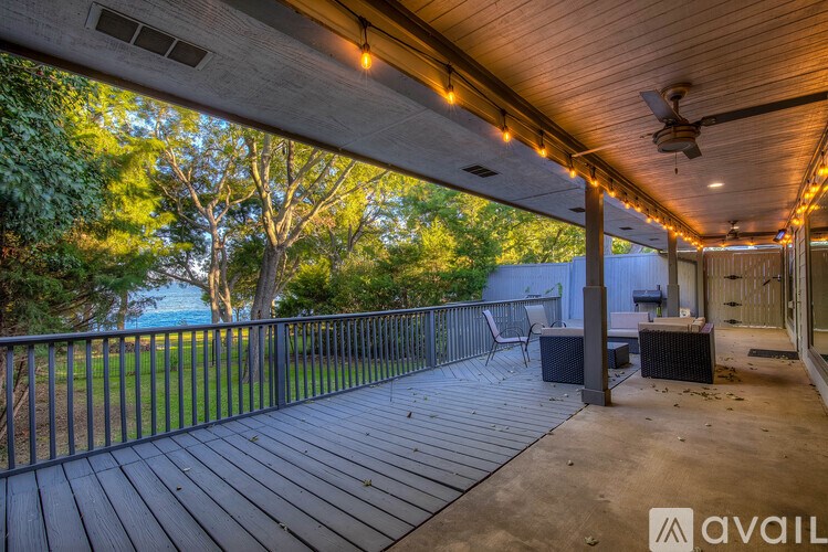 A deck with a railing and a ceiling fan.