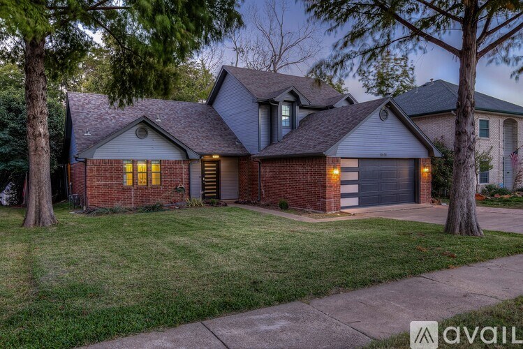 A house with a brick facade and a grey roof is shown.