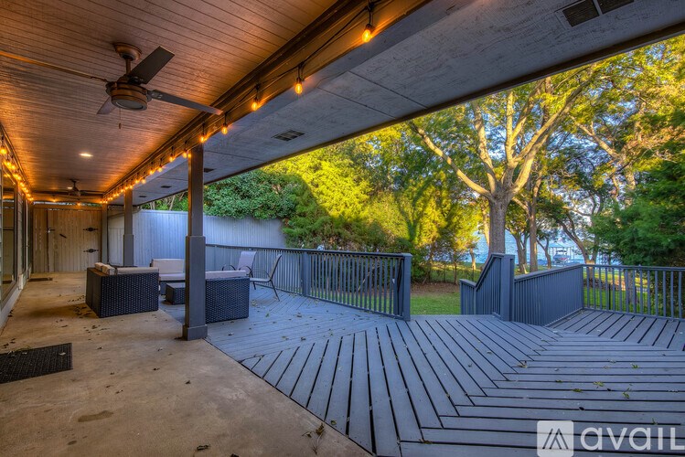A patio with a ceiling fan and a table.