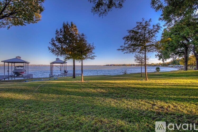 A serene lakeside scene with a gazebo and trees.