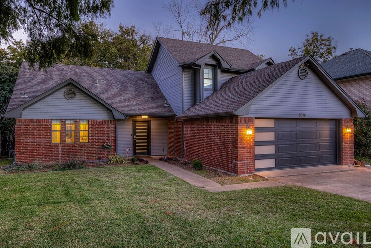 A house with a garage and a driveway is available for sale.