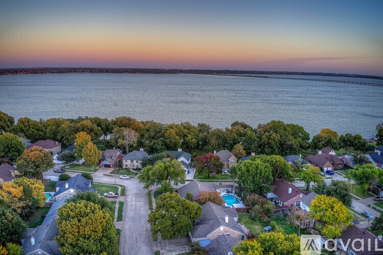A residential area with houses and trees is shown in an aerial view.