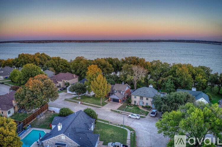 A neighborhood with houses and a body of water in the background.