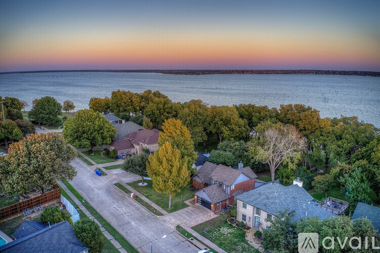 A beautiful aerial view of a residential area with houses and trees during sunset.