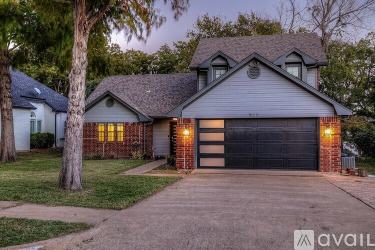 A house with a garage and a driveway in front of it.