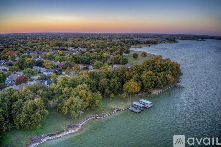 A boat is docked on a lake surrounded by trees.