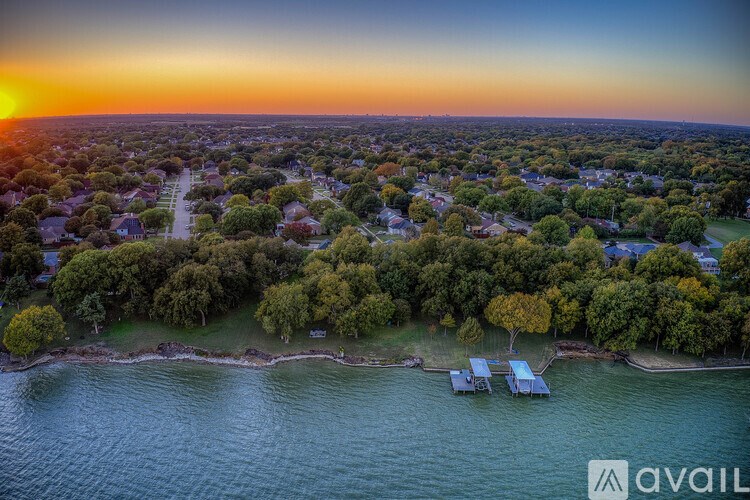 A sunset view of a residential area with houses and trees.