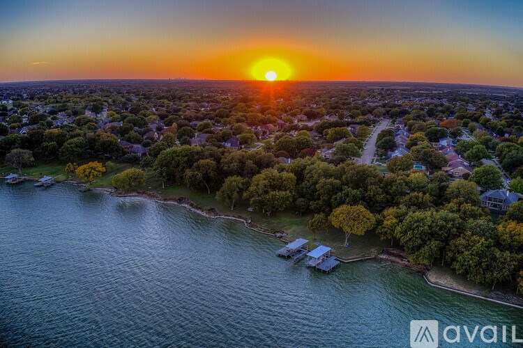 A sunset over a coastal town with a body of water in the foreground.