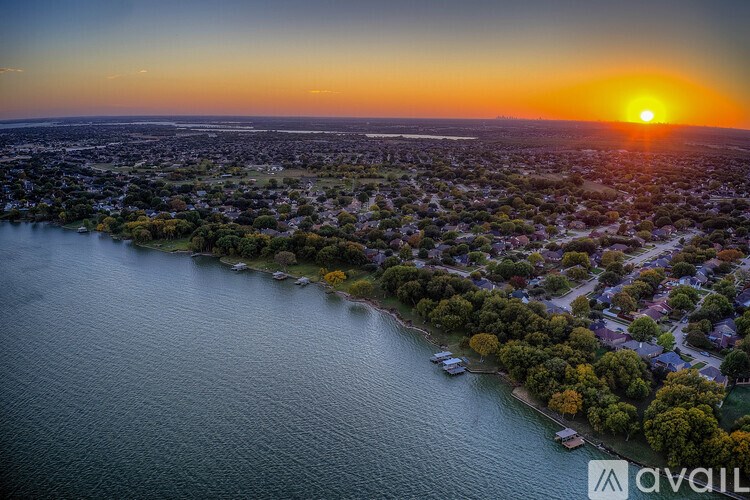 A sunset over a city with a body of water in the foreground.