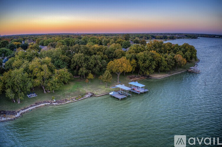 A serene landscape with a body of water, trees, and a small dock with a boat.
