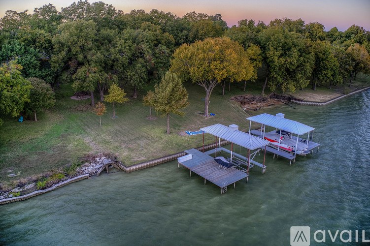 A dock with a blue roof is surrounded by trees and water.