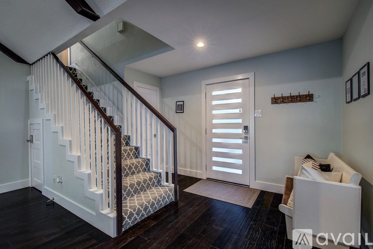 A staircase with a white railing and a white door with shutters on the side.