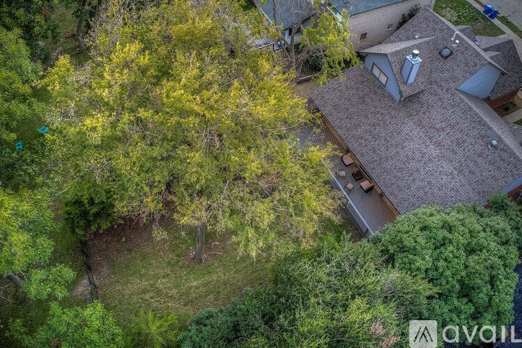 A house with a brown roof surrounded by trees.