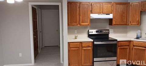 A kitchen with wooden cabinets and a black stove top oven.