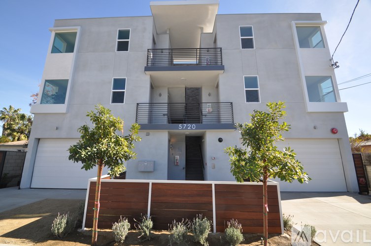 A modern two-story building with a balcony on the second floor.