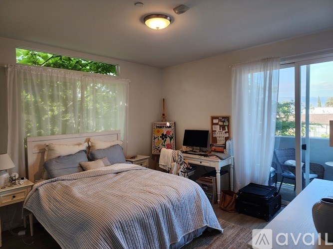 A bedroom with a bed, desk, and chair.
