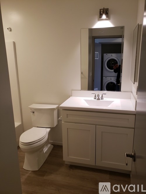 A white toilet and sink in a small bathroom.